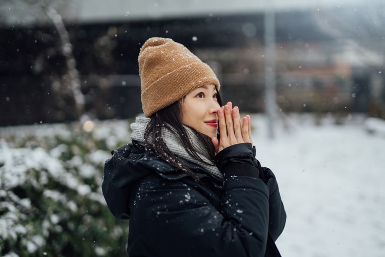 Portrait of young beautiful woman enjoying snow in the city. Beeld Getty Images