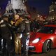 Een rode sportauto komt klem te zitten tussen demonstranten: opzet of toeval?
