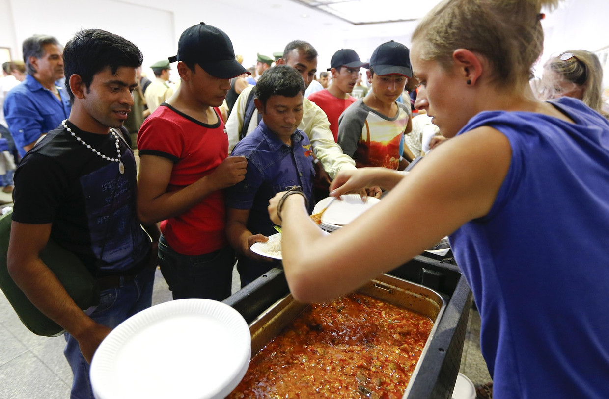 Vrijwilligers delen eten uit aan de migranten. Beeld ap