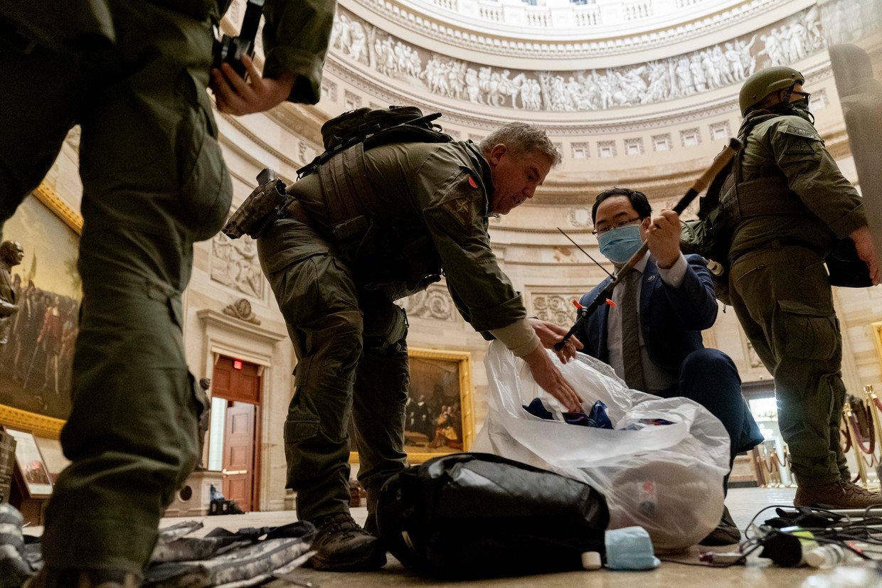 Agenten ruimen de rotunda van het Capitool op de dag nadat manifestanten het parlement innamen.  Beeld AP