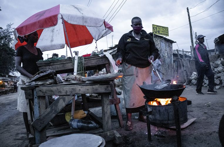 Kleine bedrijfjes verlenen hun diensten in de sloppenwijk Kibera in Nairobi, Kenia. Voor veel mensen is het leven moeilijk tijdens de lockdown nu bedrijven vroeg moeten sluiten en inwoners op tijd naar huis moeten. Beeld Donwilson Odhiambo/Getty Images