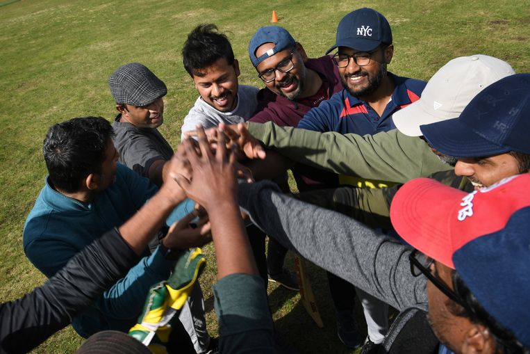 Een cricketteam van expats wenst elkaar succes voor de wedstrijd.
 Beeld Marcel van den Bergh / de Volkskrant