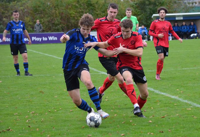 Een beeld uit het duel tussen SKNWK (blauw-zwart) en 's-Heer Arendskerke in de derde klasse H van het zaterdagvoetbal.