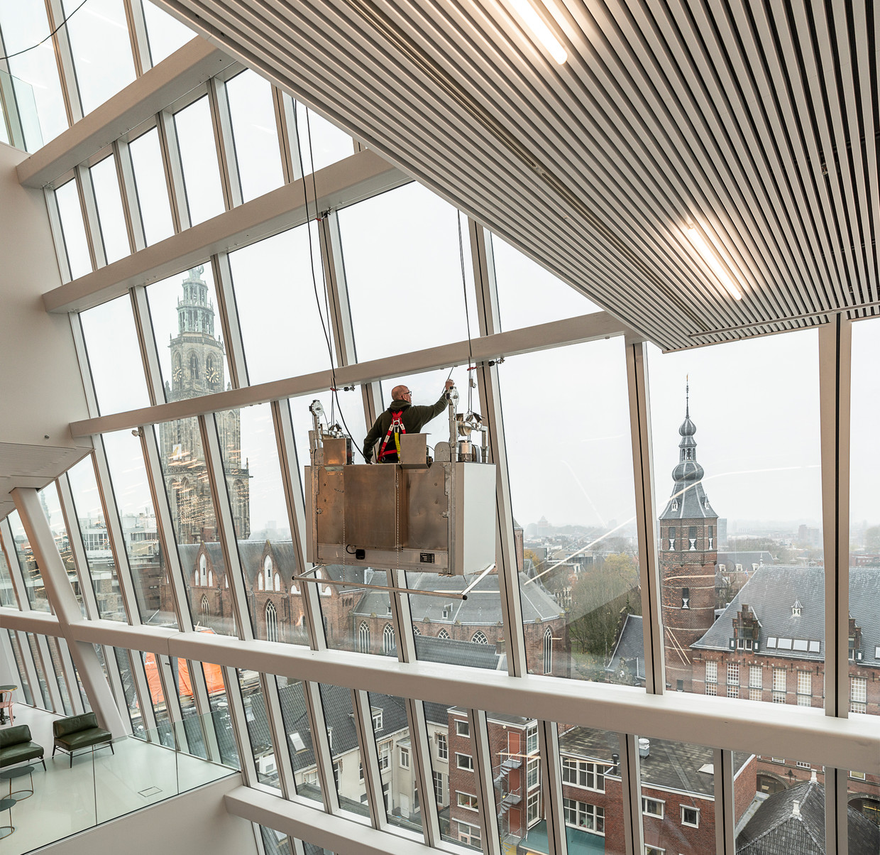 Het Groninger Forum 5 dagen voor de opening. De glazen gevel biedt telkens een ander perspectief. Beeld Harry Cock / de Volkskrant