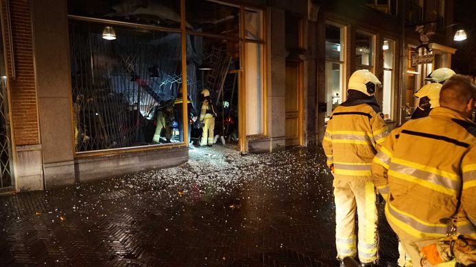 Hulpdiensten bij een kledingwinkel met dure merkkleding in Deventer, nadat een auto de gevel kapot heeft gereden tijdens een ramkraak.