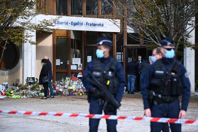 Aan de school in het Parijse Conflans-Sainte-Honorine waar leerkracht Samuel Paty door een 18-jarige Tsjetsjeen onthoofd werd, leggen mensen bloemen neer. De dader was geen leerling en woonde 100 kilometer verder.