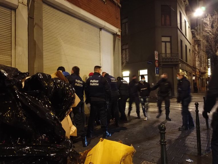 Een groepje jongeren dat na het ingaan van de avondklok nog op straat rondhangt, in de buurt van een brand, moet mee naar het commissariaat.   Beeld Stéphanie Romans