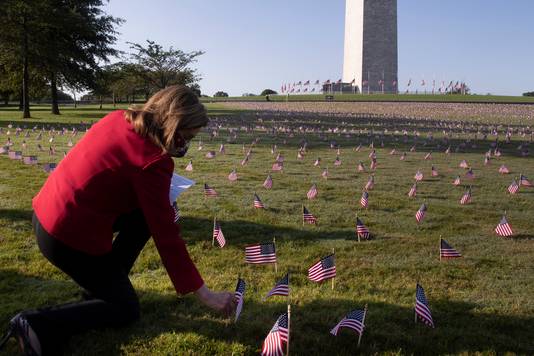 De voorzitter van het Huis van Afgevaardigden Nancy Pelosi plant een Amerikaans vlaggetje aan het Washington Monument. De 20.000 vlaggetjes moeten de 200.000 slachtoffers symboliseren.