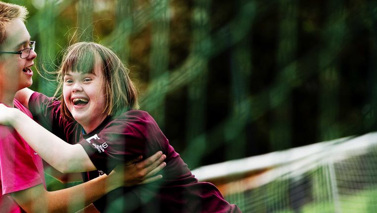 Twee deelnemers juichen tijdens het voetbaltoernooi 'Geef Down de toekomst' dat in 2013 gehouden werd op het trainingscomplex van Ajax, De Toekomst. Beeld ANP