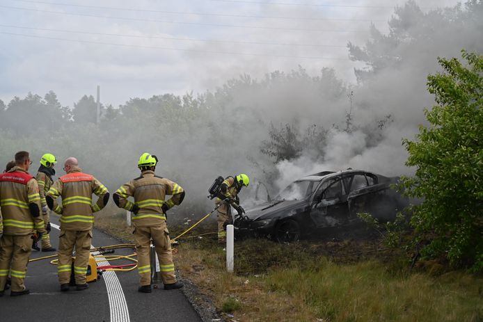 De brandweer blust de auto die in brand vloog nadat de bestuurder van de weg was geraakt op de A50-afrit Schaarsbergen bij Arnhem.