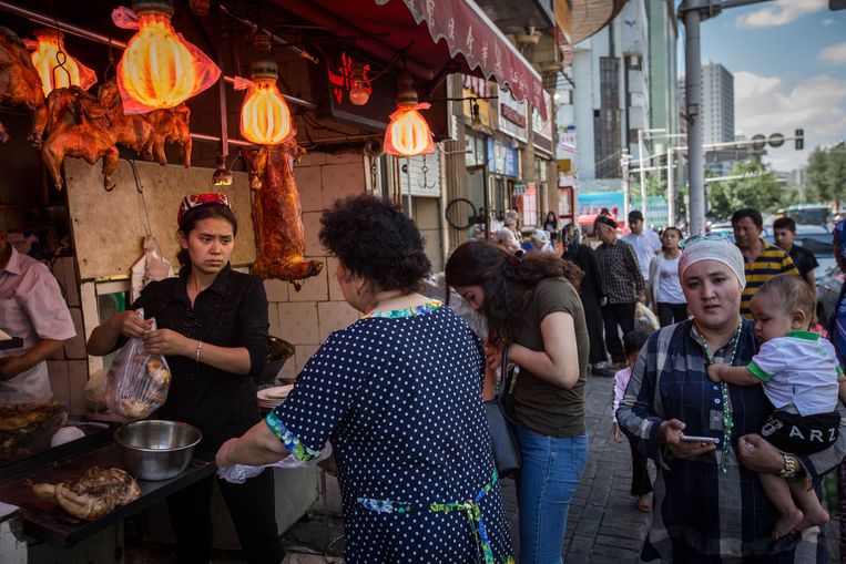  Een Oeigoerse vrouw verkoopt kip in het Oeigoerse deel van de hoofdstad Ürümqi.  Beeld Getty Images