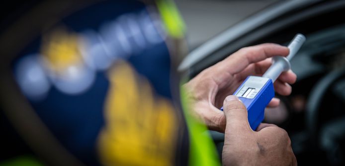 Een agent neemt tijdens een verkeerscontrole een speekseltest af.