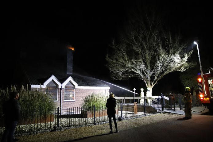 De vlammen sloegen uit de schoorsteen toen de brandweer bij de woning kwam.