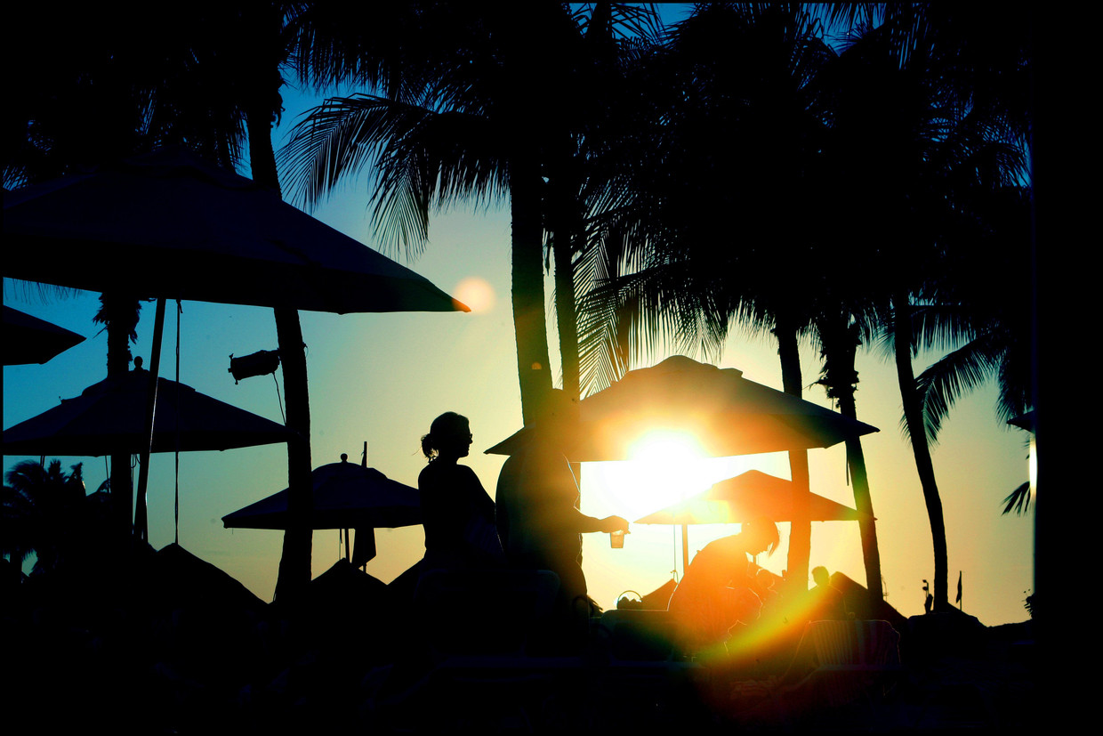 Nederlandse toeristen genieten van de zonsondergang tijdens hun vakantie op Curaçao. Beeld Hollandse Hoogte 