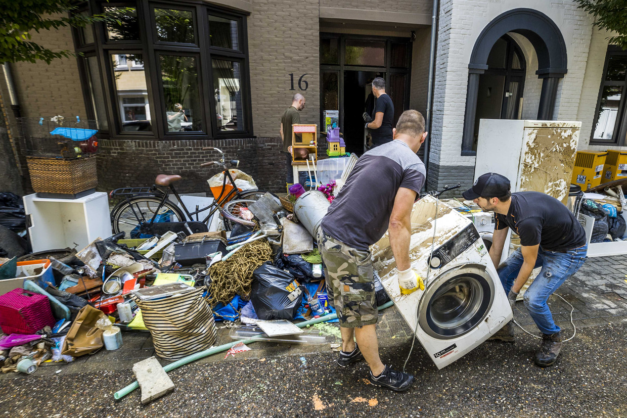 Inwoners ruimen puin na de wateroverlast in Valkenburg aan de Geul.  Beeld ANP