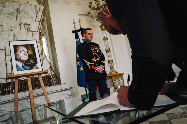 Een man tekent het condoleanceregister voor de Franse president Jacques Chirac. Beeld AFP