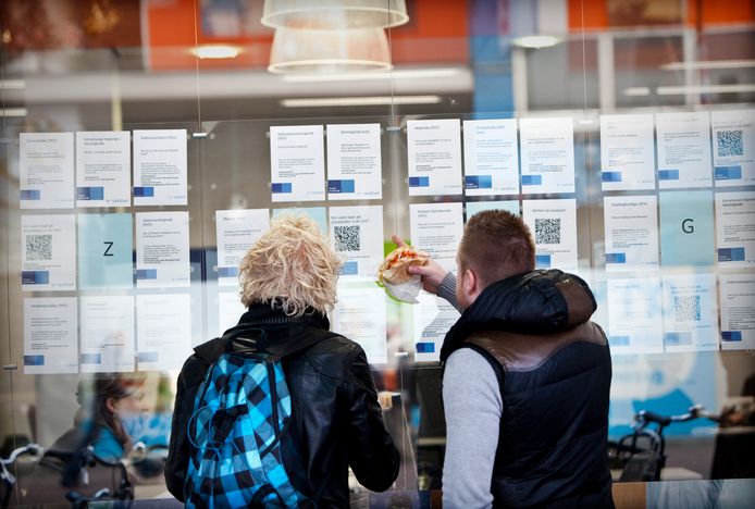 Twee belangstellenden bekijken de etalage van een uitzendbureau. Nu is de uitzendbranche nog nauwelijks geautomatiseerd