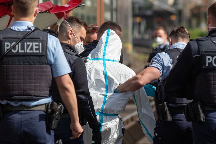 De dader wordt weggeleid door de politie.