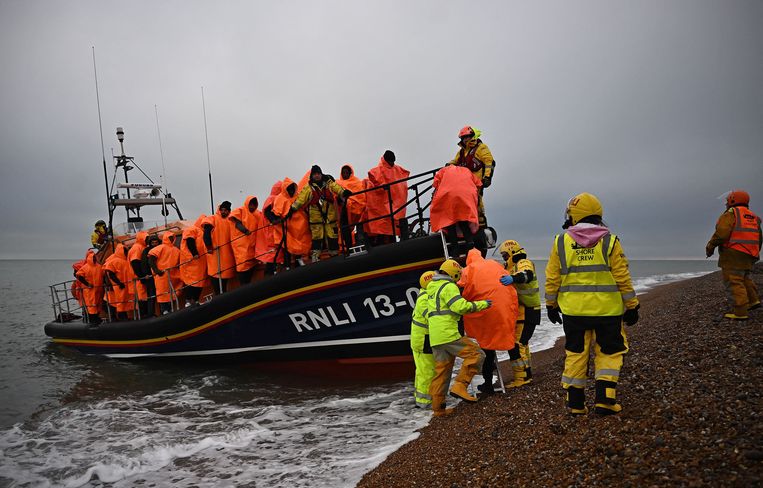 Asielzoekers die Het kanaal probeerden over te steken, worden aan land geholpen door een reddingsboot van de Royal National Lifeboat Institution (RNLI). Beeld AFP
