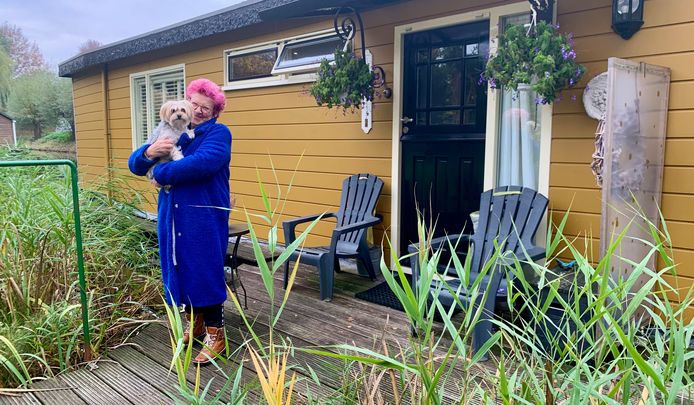 Coby Cremer voor haar woonboot met hond Guusje.