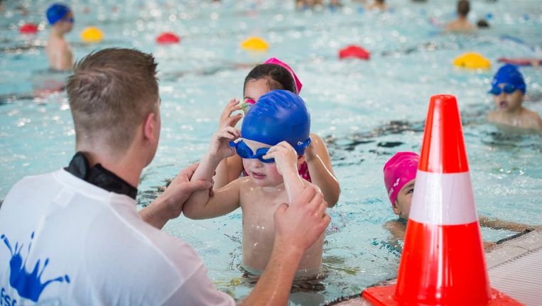 De badmeester helpt een jongen zijn zwembril om te doen in het Hofbad in Den Haag Beeld anp