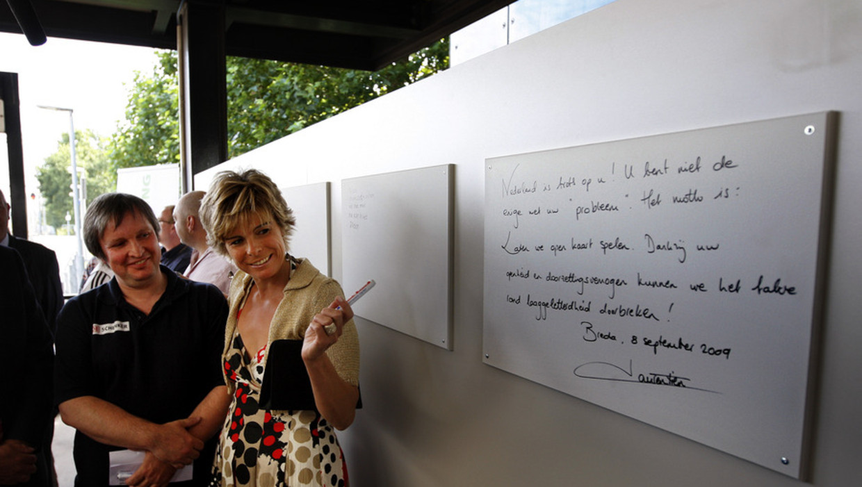 Prinses Laurentien schrijft, samen met analfabeten die een cursus lezen en schrijven volgen, een tekst op een bord op het station van Breda. Beeld anp