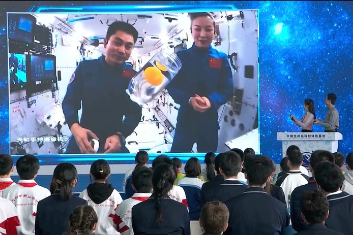 Taikonauten Wang Yaping (rechts) Ye Guangfu (links) demonstreren via een videoverbinding ruimte-experimenten voor schoolkinderen.