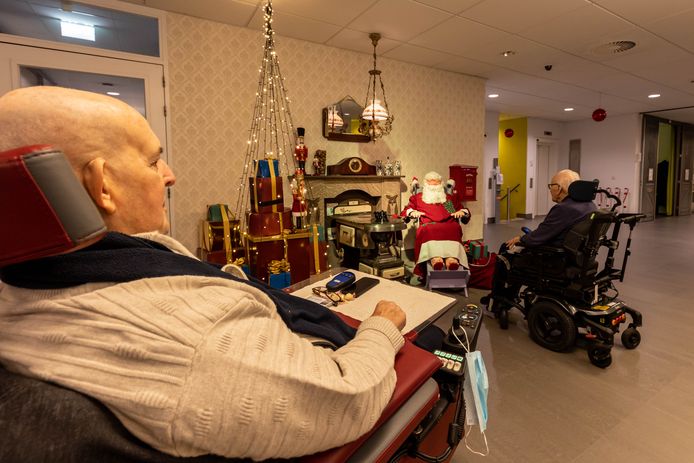 Bewoners staan stil bij handgemaakte kerstman.