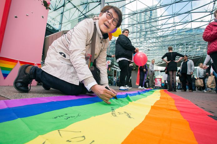 Astrid schrijft een positieve boodschap op een tien meter lange regenboogvlag in het Stadshart. De stad vraagt geregeld positieve aandacht voor mensen met een andere geaardheid. Het Rainbow Café, dat na lange tijd weer heropent, sluit hierbij aan.
