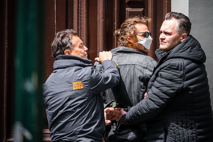 Jasper van den Elshout (met mondkapje) wordt door twee beveiligers van Forum voor Democratie in bedwang gehouden.