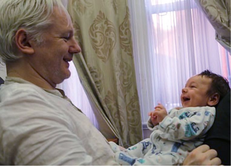 Julian Assange met zijn zoontje Gabriel, toen hij nog in de ambassade verbleef. 'Hun papa is tegenwoordig niet meer dan een stem aan de telefoon, want nu hij in de gevangenis zit, mogen we niet videobellen met elkaar.' Beeld 
