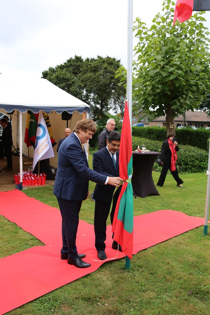 Gerard Huiting en de Maledivische secretaris van Buitenlandse Zaken Abdul Ghafoor Mohamed hangen samen de vlag van de Malediven op.