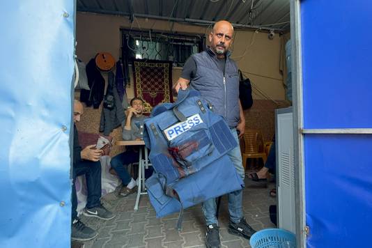 Een man toont het kogelwerende vest van Al Jazeera-journalist Wael Al-Dahdouh, die geraakt werd bij een raketinslag in Khan Younis. 