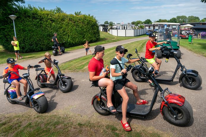 Jongeren rijden op elektrische stepscooters rond op camping de Rietschoof. De camping aan de Maas meet liefst 20 hectare, ruimte genoeg voor de 1,5 meterregels.