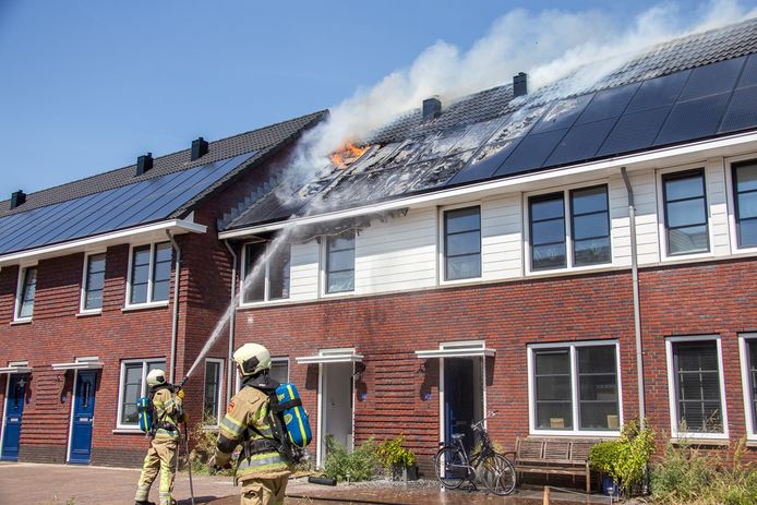 Brandweerlieden bestrijden de vlammen op het dak van drie getroffen woningen in Vinkeveen deze week.