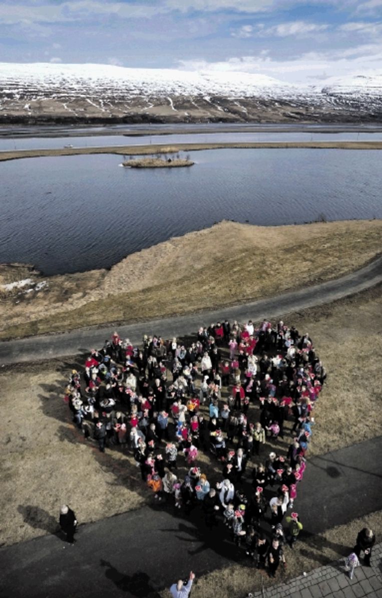 Als dank voor het elektrische hart (ter grootte van een voetbalveld) dat in de bergen achter hen is gemonteerd, stellen de inwoners van Akureyri zich op in de vorm van een hart. (FOTO LÃ¿RA STEFÃ¿NSDÃ¿TTIR) Beeld 