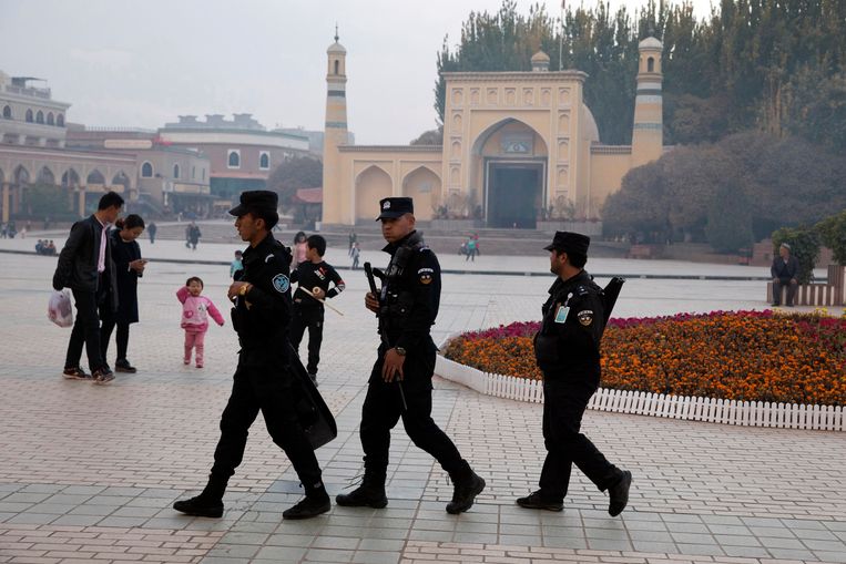 Oeigoerse bewakers patrouilleren bij de Id Kah-moskee in het Chinese Kasjgar, in het westen van de regio Xinjiang. Beeld AP