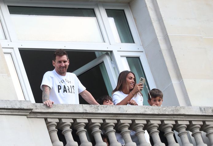 Lionel Messi, Antonella Roccuzzo en hun kinderen Thiago en Mateo begroeten vanaf het balkon van hun hotelkamer de honderden PSG-fans.