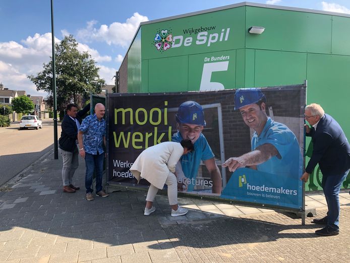 Wethouder Coby van der Pas (midden) tilt met voorzitter Hans van Zantvoort van de wijkvereniging en vrijwilliger/beheerder Peter Schepers het bouwhek weg. Daarmee is de Spil 2.0 geopend.