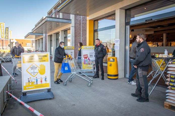Toezicht bij de ingang van een supermarkt in Sint-Annaland: mondkapjes, gedesinfecteerde karretjes en vooral voldoende afstand.