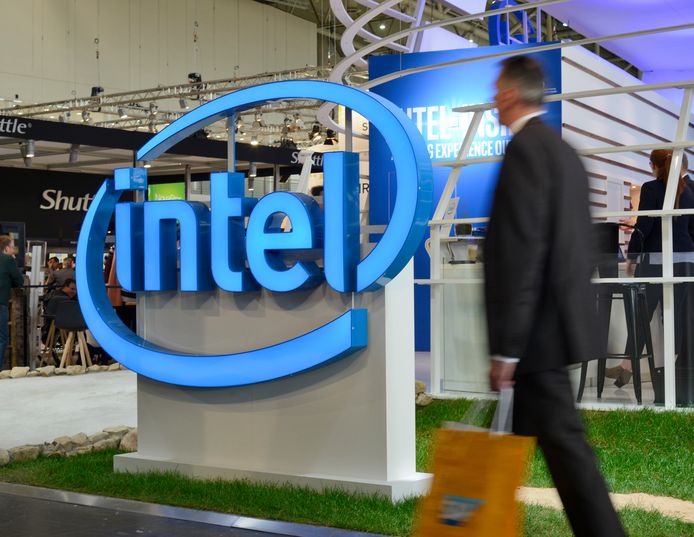 Een man loopt langs het logo van Intel.