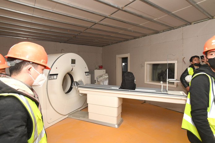 Bouwvakkers in een ruimte met een CT-scanner in het Huoshenshan-ziekenhuis