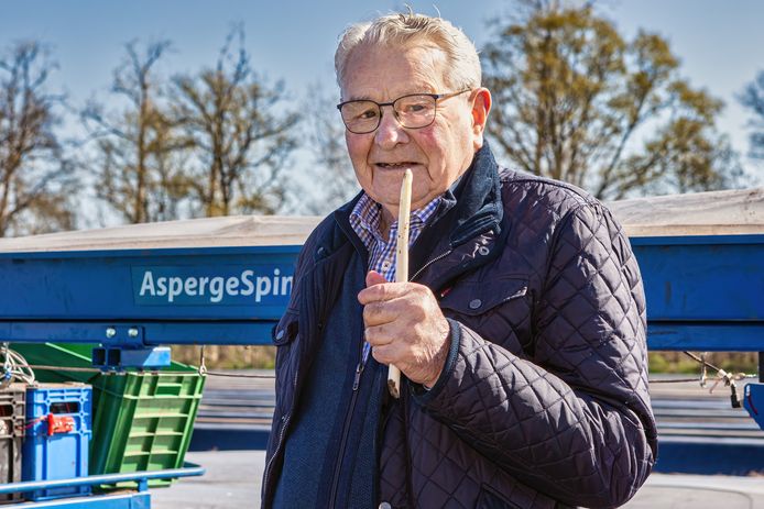 De eerste steek van de Brabantse Wal asperges is een feit. De heer Van den Kieboom, 96 jaar jong, toont de asperge die hij net heeft gestoken.