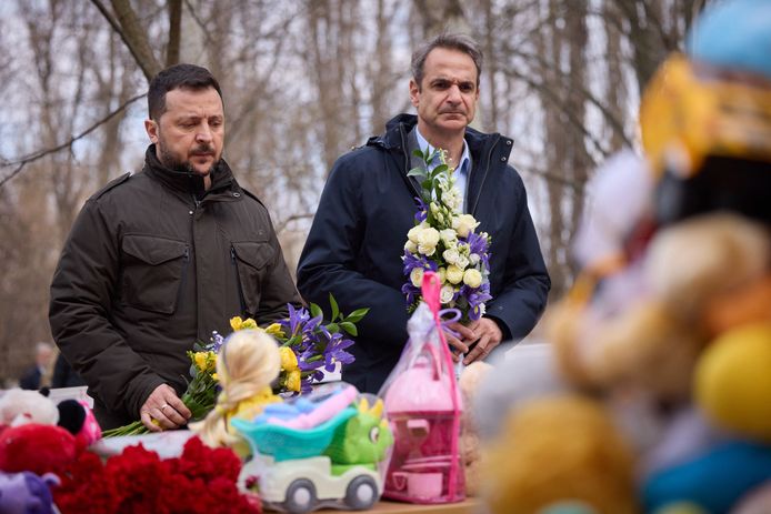 De Oekraïense president Volodymyr Zelensky en de Griekse premier Kyriakos Mitsotakis bij een berg beertjes, speelgoed en bloemen vlakbij een flatgebouw in Odesa waar zaterdag twaalf mensen omkwamen bij een Russische drone-aanval, onder wie vijf kinderen.