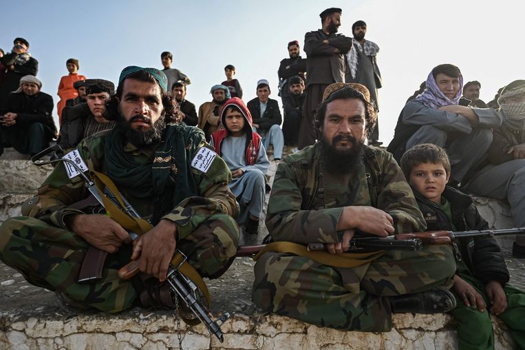 Talibanstrijders en Afghaanse burgers in Mazar-i-Sharif. Beeld AFP