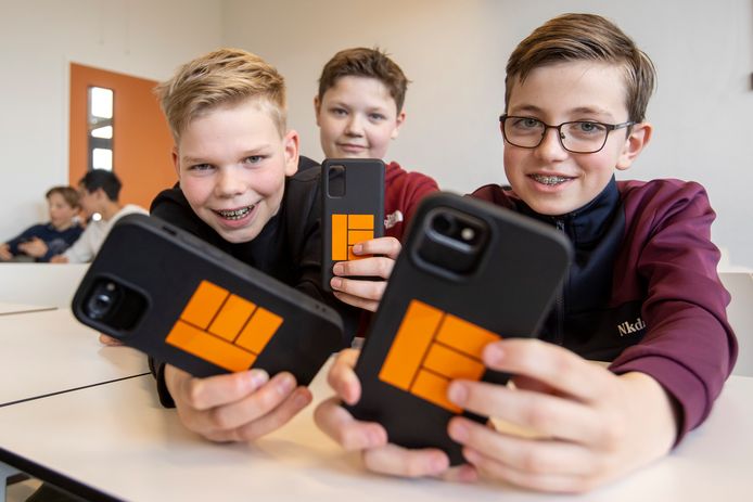 Leerlingen Dean Bosveld, Brick Olde Olthof en Hidde Klutman (van links naar rechts) met het hoesje met Erasmuslogo, onderdeel van een project over nepnieuws.