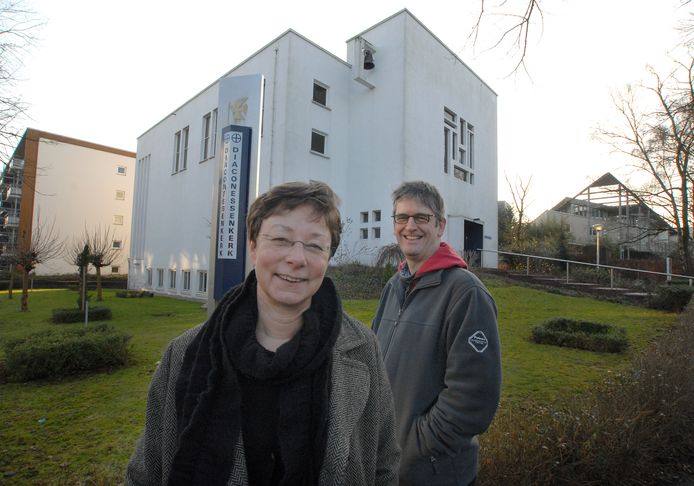 Dominee Monique Maan en ouderling Peter Hoeve staan voor de Diaconessenkerk uit 1959. Het is één van de kerken die in de verkoop gaat. De foto is uit het archief.