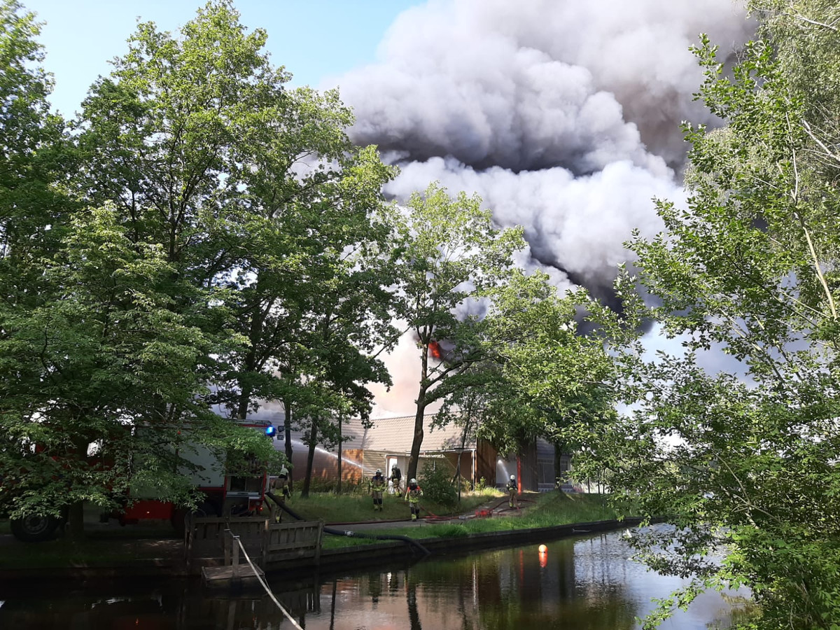 De brandweer blust de brand in het hoofdgebouw van de Beekse Bergen.