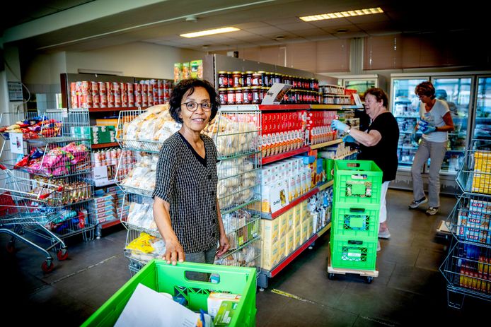 De voedselbank van Druten krijgt 4500 euro extra. Coördinator Letty Broere met op de achtergrond medewerkers die de voorraad aanvullen.