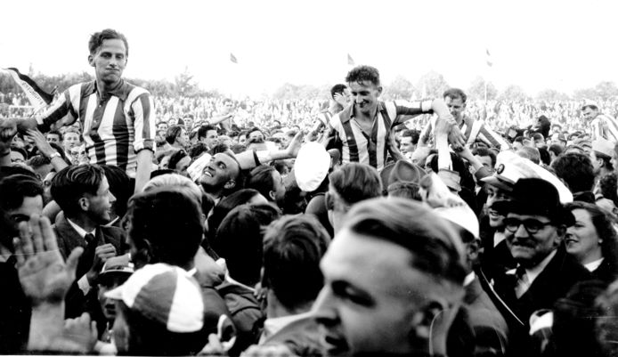 De foto is gemaakt na het behalen van het landskampioenschap tegen DOS in 1954. De spelers op de schouders zijn v.l.n.r. Willy Schmidt, Noud van Melis, achter hem met een hand op het oor, Cor Vlemmix en Frans van Tuijl en Frans Tebak